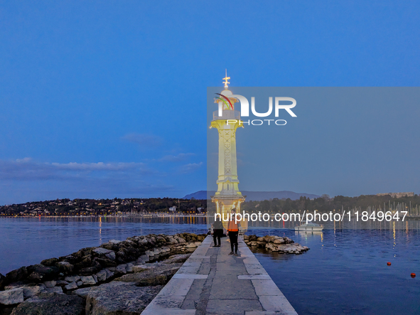 People enjoy an early evening on Lake Geneva in Geneva, Switzerland, on April 9, 2023, watching the Phare des Paquis, a lighthouse on Lake G...