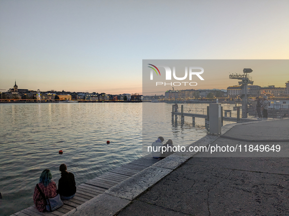 People take an early evening walk at Lake Geneva in Geneva, Switzerland, on April 9, 2023. 