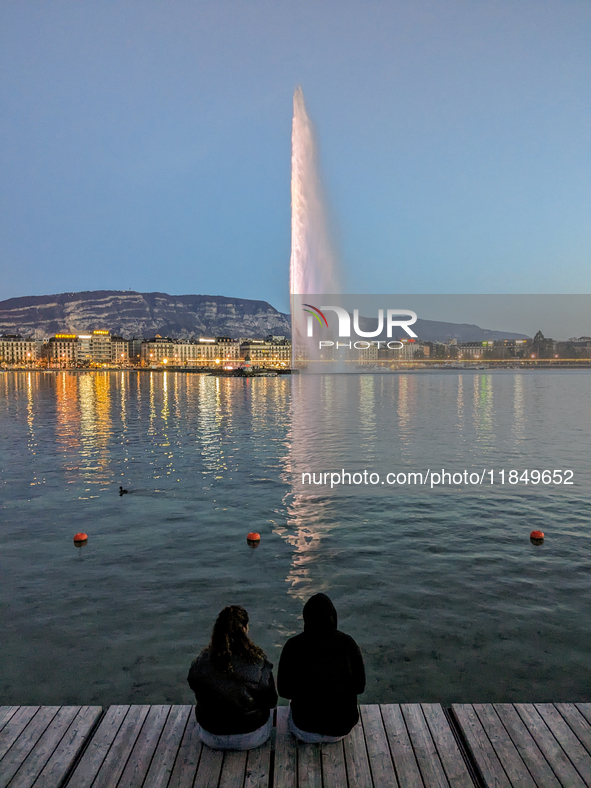 People enjoy an early evening on Lake Geneva in Geneva, Switzerland, on April 9, 2023, watching the Jet d'eau, a fountain in Lake Geneva wit...