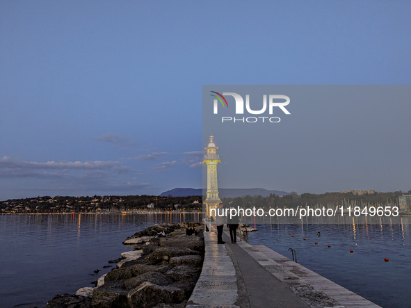 People enjoy an early evening on Lake Geneva in Geneva, Switzerland, on April 9, 2023, watching the Phare des Paquis, a lighthouse on Lake G...