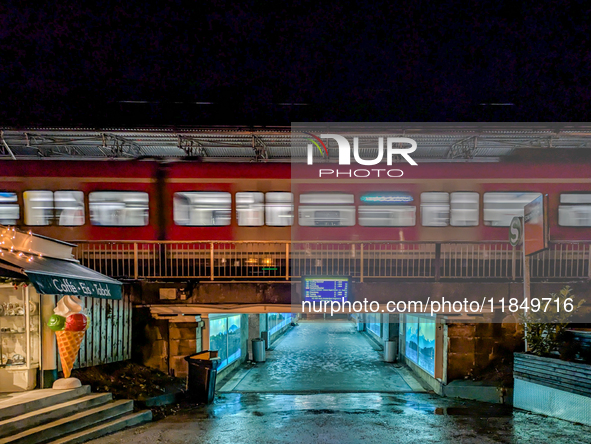 At Starnberg Station in Upper Bavaria, Germany, on December 7, 2024, a suburban S-Bahn train, line S6, moves at night, connecting the Munich...