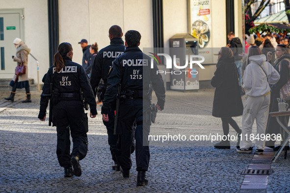 Three police officers patrol in the city center of Munich, Germany, on November 30, 2024. 