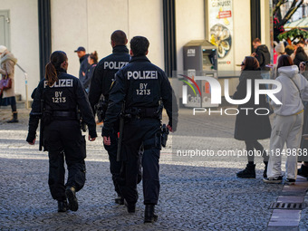 Three police officers patrol in the city center of Munich, Germany, on November 30, 2024. (