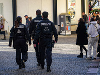 Three police officers patrol in the city center of Munich, Germany, on November 30, 2024. (