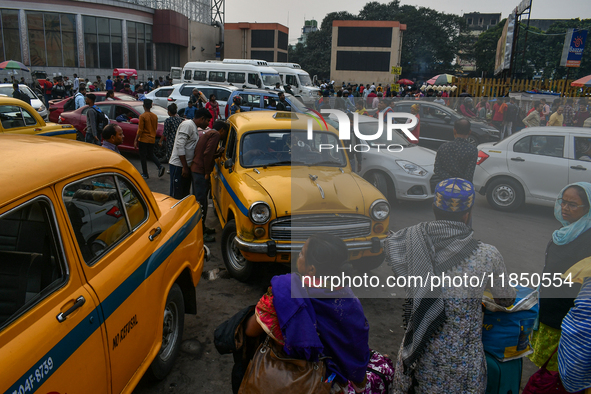 Passengers walk past yellow taxis near Sealdah railway station in Kolkata. 