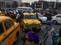 Passengers walk past yellow taxis near Sealdah railway station in Kolkata. (