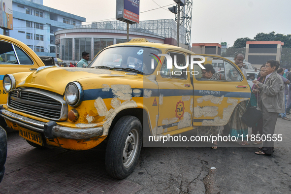 Passengers board a yellow taxi near Sealdah railway station in Kolkata, India. 