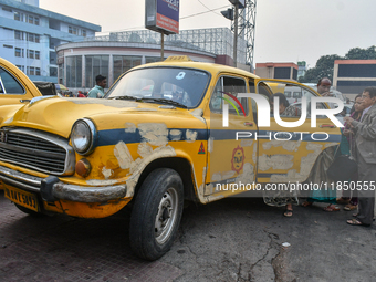 Passengers board a yellow taxi near Sealdah railway station in Kolkata, India. (