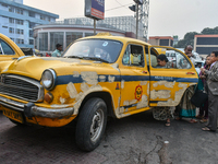 Passengers board a yellow taxi near Sealdah railway station in Kolkata, India. (