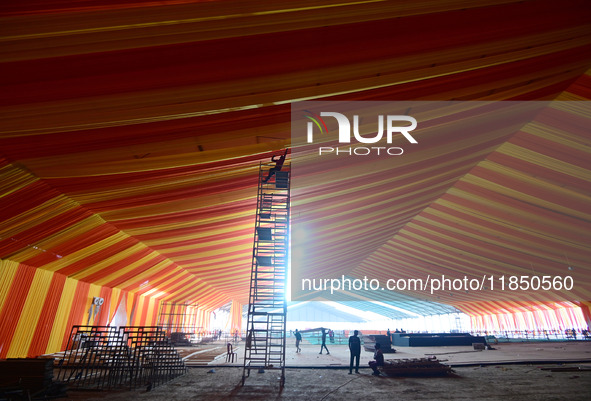 Workers apply the final touches to a temporary structure on the banks of Sangam, the confluence of the Rivers Ganges, Yamuna, and mythical S...