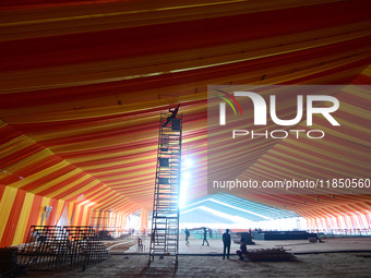 Workers apply the final touches to a temporary structure on the banks of Sangam, the confluence of the Rivers Ganges, Yamuna, and mythical S...