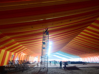 Workers apply the final touches to a temporary structure on the banks of Sangam, the confluence of the Rivers Ganges, Yamuna, and mythical S...