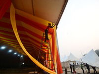 Workers apply the final touches to a temporary structure on the banks of Sangam, the confluence of the Rivers Ganges, Yamuna, and mythical S...