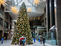 People pose for a selfie by a large Christmas tree decorated in Toronto, Ontario, Canada, on December 8, 2024. (