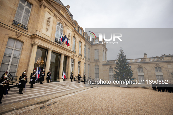 An illustration depicts the entrance to the presidential palace with the French Republican Guard in the courtyard of the Elysee Palace in Pa...