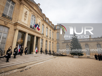 An illustration depicts the entrance to the presidential palace with the French Republican Guard in the courtyard of the Elysee Palace in Pa...