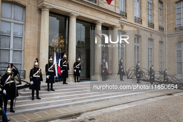 An illustration depicts the entrance to the presidential palace with the French Republican Guard in the courtyard of the Elysee Palace in Pa...