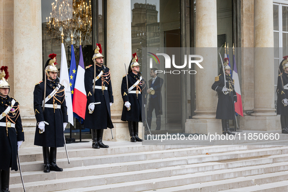 An illustration depicts the entrance to the presidential palace with the French Republican Guard in the courtyard of the Elysee Palace in Pa...