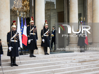 An illustration depicts the entrance to the presidential palace with the French Republican Guard in the courtyard of the Elysee Palace in Pa...