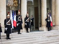 An illustration depicts the entrance to the presidential palace with the French Republican Guard in the courtyard of the Elysee Palace in Pa...