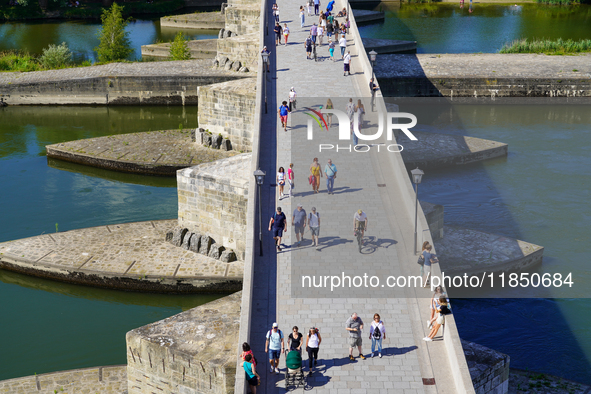 Pedestrians cross the historic Stone Bridge in Regensburg, Germany, on June 25, 2022. Constructed in the 12th century, this bridge spans the...