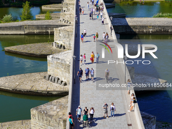 Pedestrians cross the historic Stone Bridge in Regensburg, Germany, on June 25, 2022. Constructed in the 12th century, this bridge spans the...