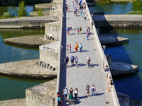 Pedestrians cross the historic Stone Bridge in Regensburg, Germany, on June 25, 2022. Constructed in the 12th century, this bridge spans the...