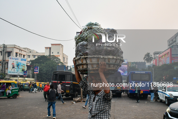 A laborer carries vegetables near Sealdah Railway Station. 