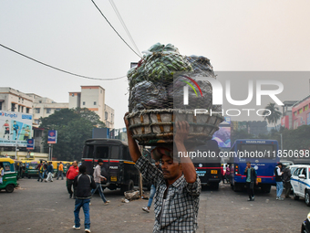 A laborer carries vegetables near Sealdah Railway Station. (