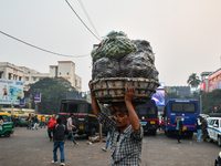 A laborer carries vegetables near Sealdah Railway Station. (