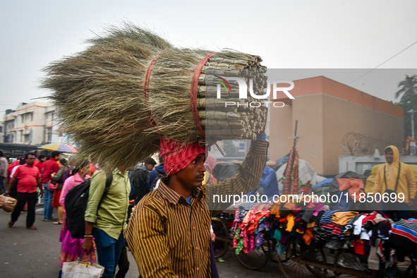 A laborer carries brooms near Sealdah Railway station. 