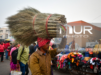 A laborer carries brooms near Sealdah Railway station. (