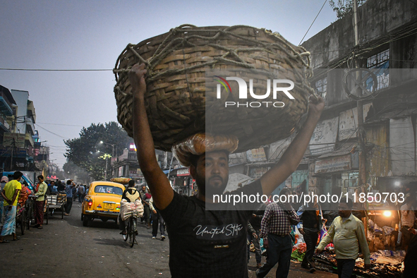 A laborer carries vegetables at Koley market in Kolkata, India, one of the biggest vegetable wholesale markets in Southeast Asia. 