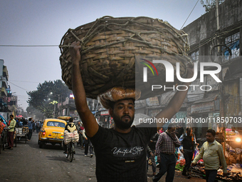 A laborer carries vegetables at Koley market in Kolkata, India, one of the biggest vegetable wholesale markets in Southeast Asia. (