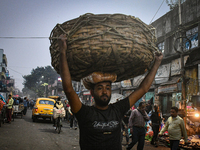 A laborer carries vegetables at Koley market in Kolkata, India, one of the biggest vegetable wholesale markets in Southeast Asia. (