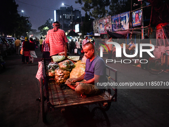 A vegetable seller counts money while his van driver pulls the van full of vegetables in Kolkata. (