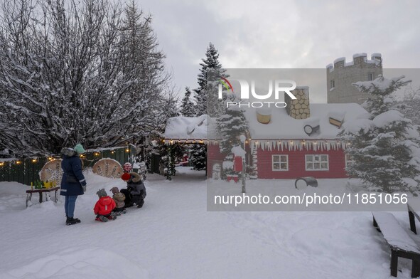 People interact at one of the entrances to a Christmas village in Akureyri, Iceland, on November 30, 2024. Christmas in Iceland, known as Jo...