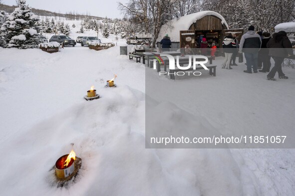 People interact at one of the entrances to a Christmas village in Akureyri, Iceland, on November 30, 2024. Christmas in Iceland, known as Jo...