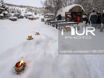 People interact at one of the entrances to a Christmas village in Akureyri, Iceland, on November 30, 2024. Christmas in Iceland, known as Jo...