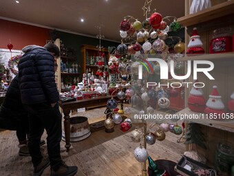 Several people look at decorations at a Christmas market in the town of Akureyri, Iceland, on November 30, 2024. Christmas in Iceland, known...