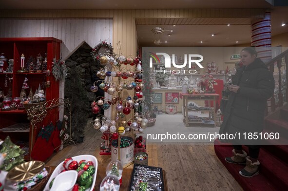 A person looks at decorations at a Christmas market in the town of Akureyri, Iceland, on November 30, 2024. Christmas in Iceland, known as J...