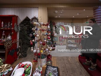 A person looks at decorations at a Christmas market in the town of Akureyri, Iceland, on November 30, 2024. Christmas in Iceland, known as J...