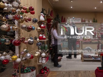 Several people look at decorations at a Christmas market in the town of Akureyri, Iceland, on November 30, 2024. Christmas in Iceland, known...