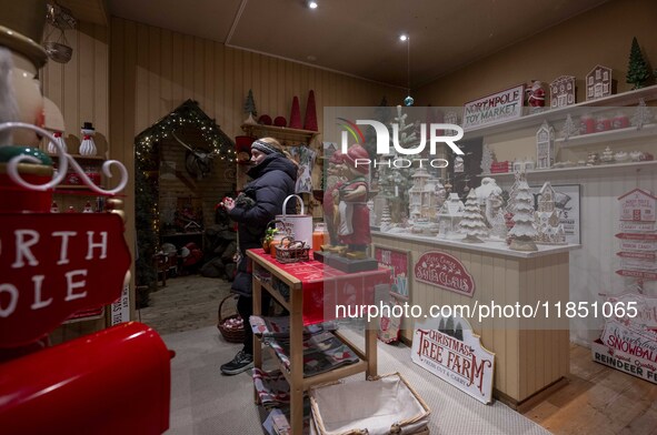 A person looks at decorations at a Christmas market in the town of Akureyri, Iceland, on November 30, 2024. Christmas in Iceland, known as J...