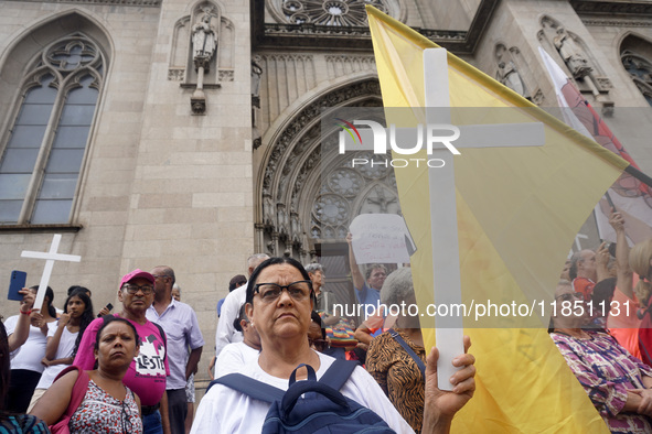 People hold crosses during a demonstration in downtown Sao Paulo, Brazil, on December 9, 2024, to protest against police violence following...