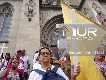 People hold crosses during a demonstration in downtown Sao Paulo, Brazil, on December 9, 2024, to protest against police violence following...