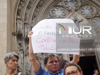 People hold crosses during a demonstration in downtown Sao Paulo, Brazil, on December 9, 2024, to protest against police violence following...