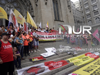 People hold crosses during a demonstration in downtown Sao Paulo, Brazil, on December 9, 2024, to protest against police violence following...