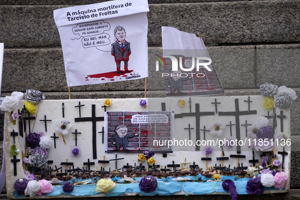 People hold crosses during a demonstration in downtown Sao Paulo, Brazil, on December 9, 2024, to protest against police violence following...