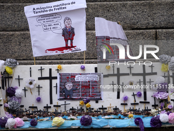 People hold crosses during a demonstration in downtown Sao Paulo, Brazil, on December 9, 2024, to protest against police violence following...